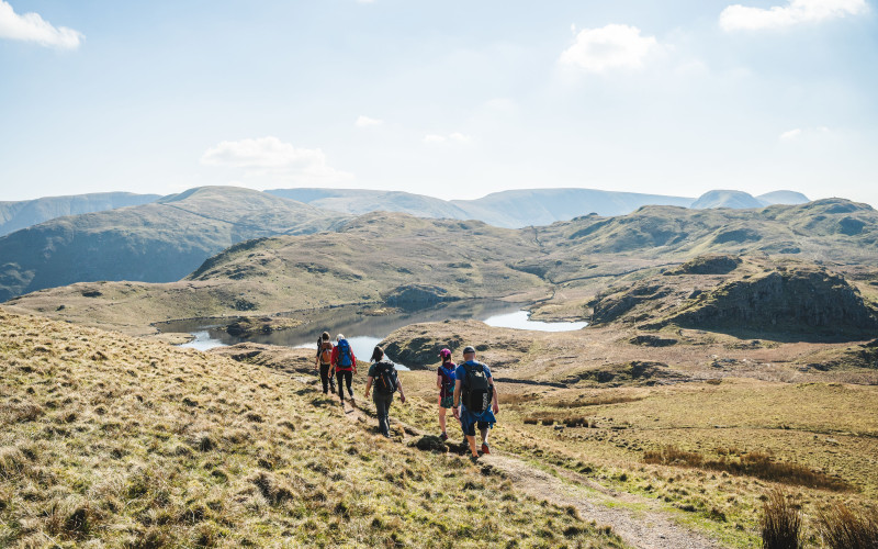 Walkers walking down the fell in the sun