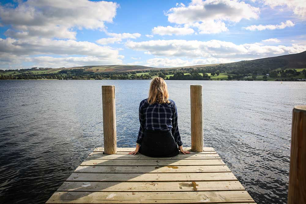 Image of someone sat on a lake dock