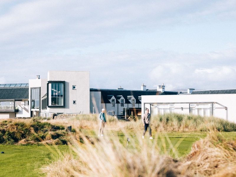 Guests playing social golf at Another Place The Machrie, hotel in the background