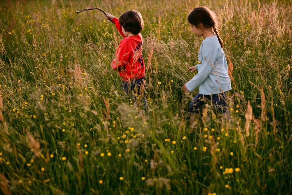 Children running around the grounds at Another Place, The Lake in the summer