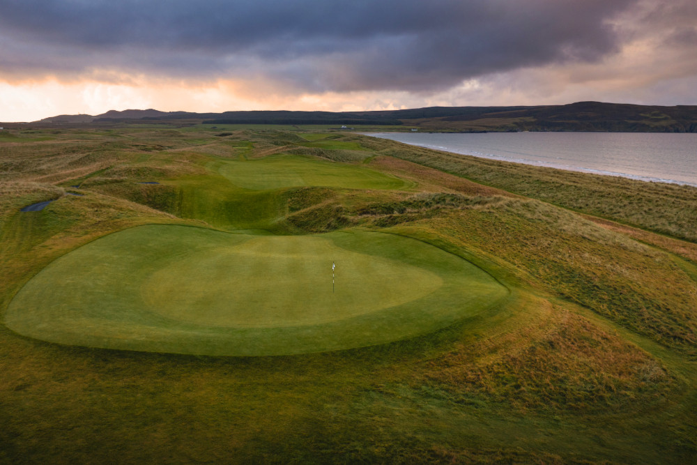 Aerial shot of the raised green at the 8th hole of The Machrie, Islay golf course, looking out over the sea
