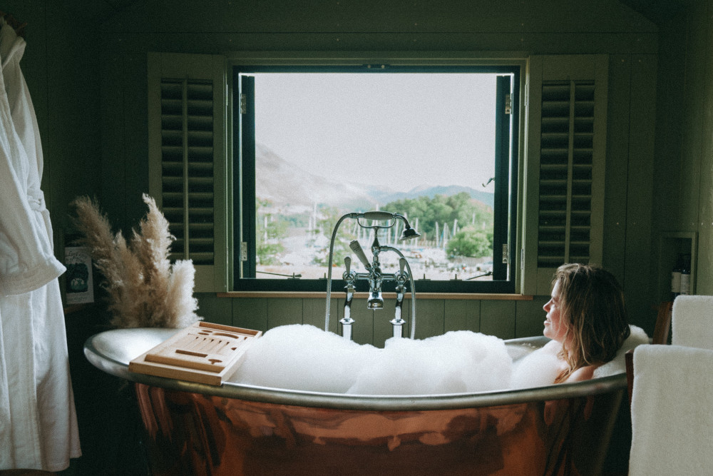 Woman in the copper bath in the shepherd hut window