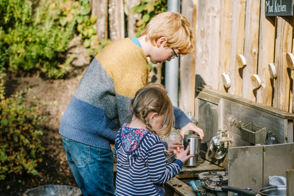 Children using the outdoor kitchen in Kids' Zone at Another Place, The Lake