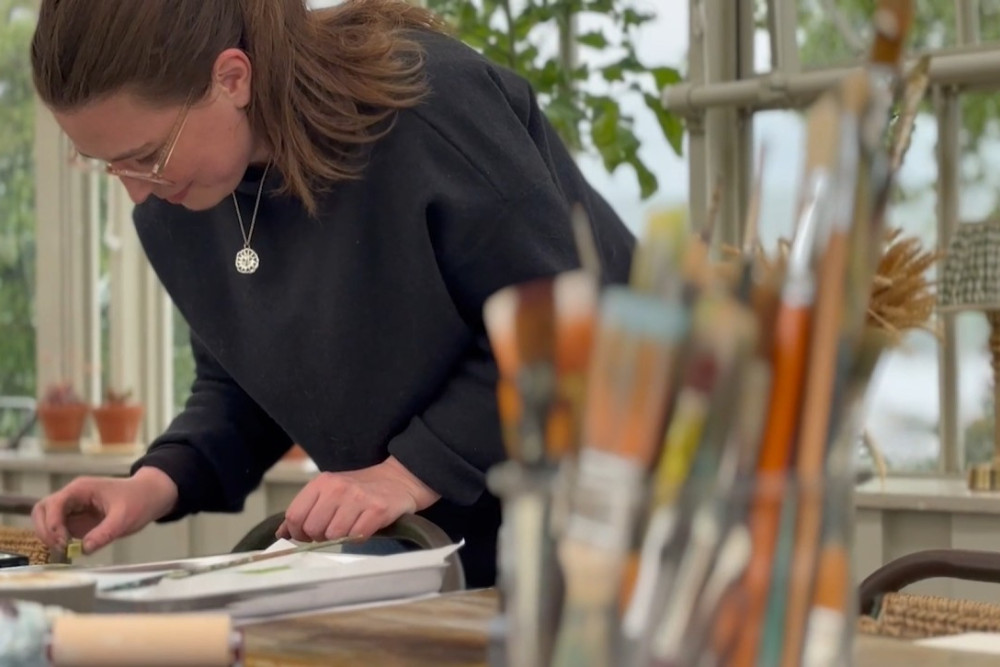Emma Carlisle painting in The Glasshouse during her artist in residence