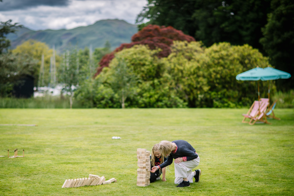 Woman and child playing Jenga on the lawn at Another Place, The Lake
