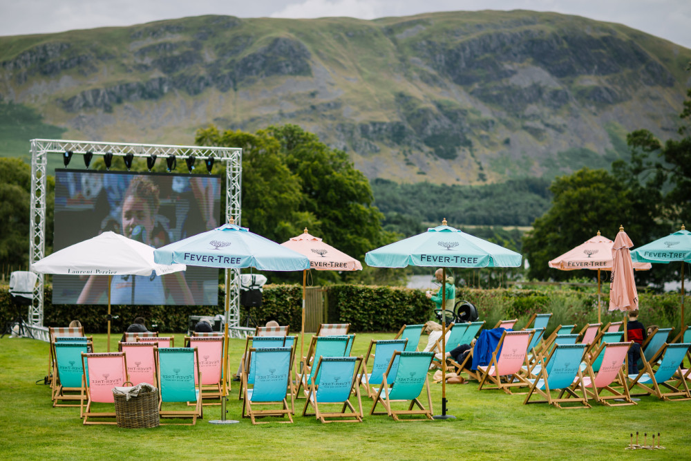Game set and match event overlooking the fells and Ullswater, with a big screen showing Wimbledon and deckchairs with parasols 