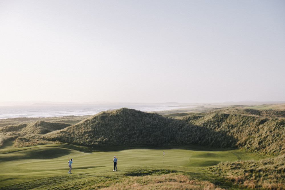 Two people playing The Machrie, Islay golf course