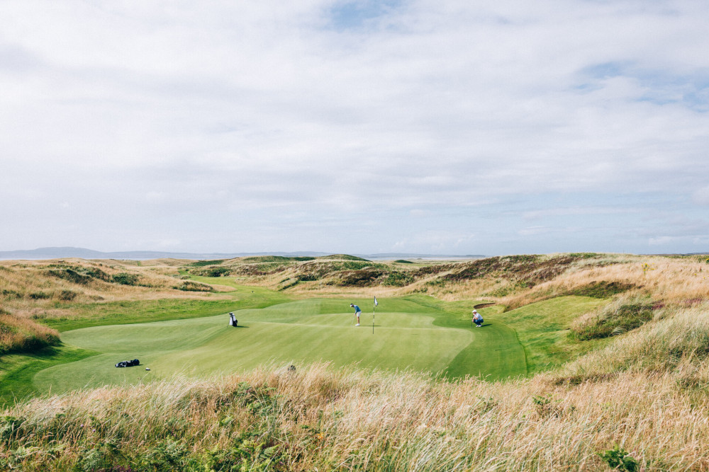 Two people playing golf on The Machrie