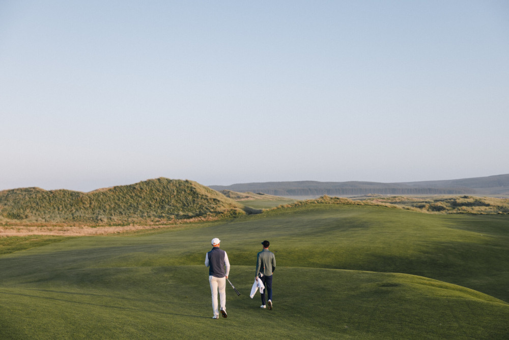 Two men walking along The Machrie golf course