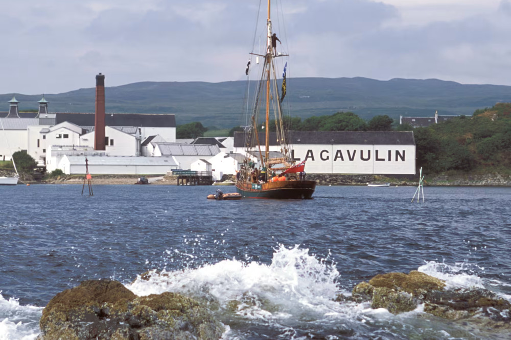 A picture of Lagavulin Legend Iain McArthur holding a bottle of the whisky named after him