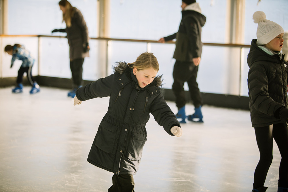 Girl skating on the ice rink at another place the lake